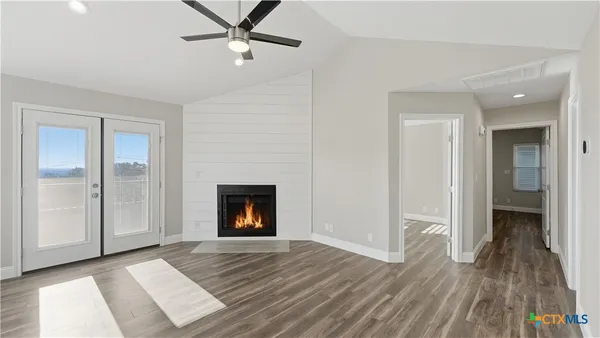 wooden floor fireplace and windows in an empty room