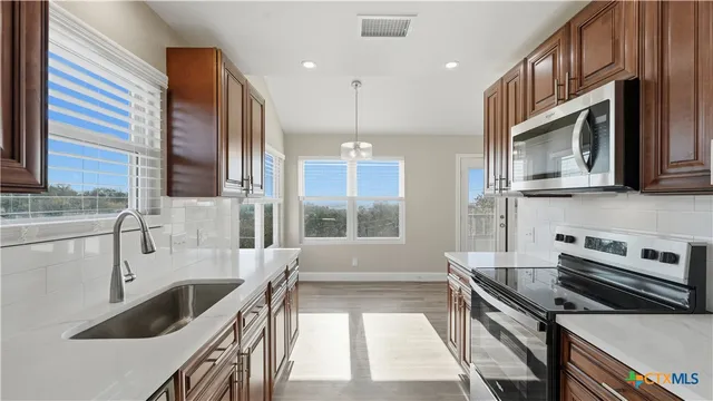 a view of an empty room with a fireplace and a window