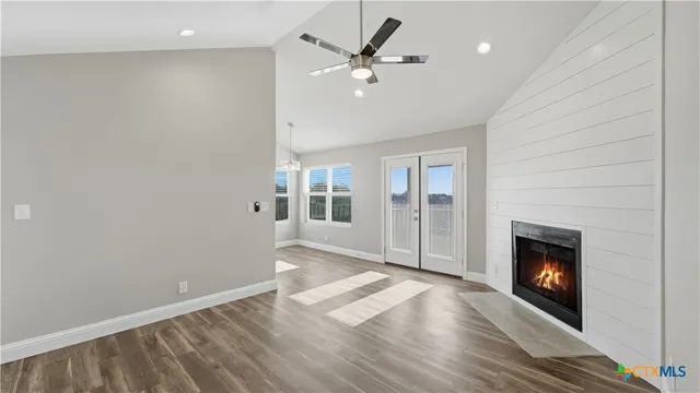 wooden floor fireplace and windows in an empty room