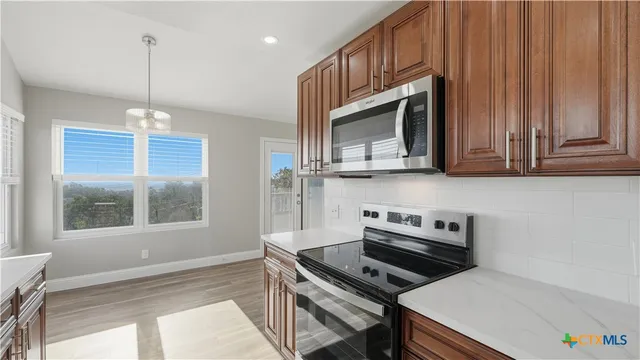 a kitchen with stainless steel appliances a stove a microwave and a sink