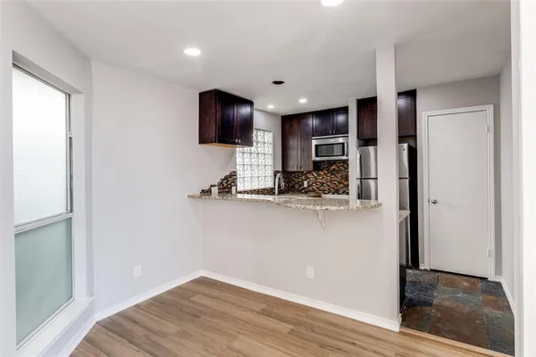 a view of kitchen with stainless steel appliances kitchen island microwave and refrigerator