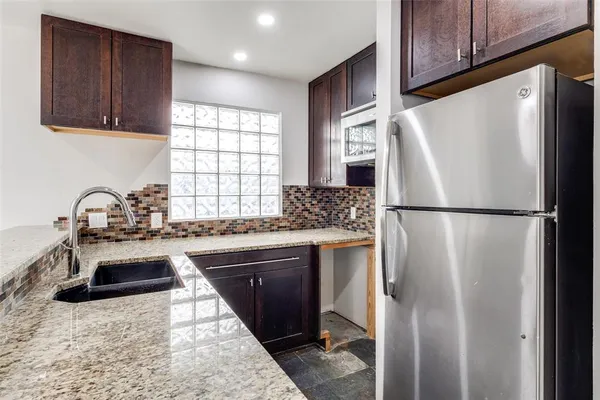 a kitchen with stainless steel appliances granite countertop a refrigerator sink and cabinets