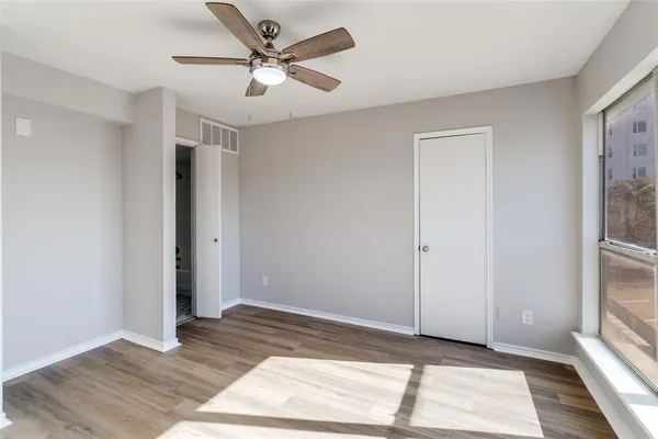 a view of a room with a ceiling fan and wooden floor