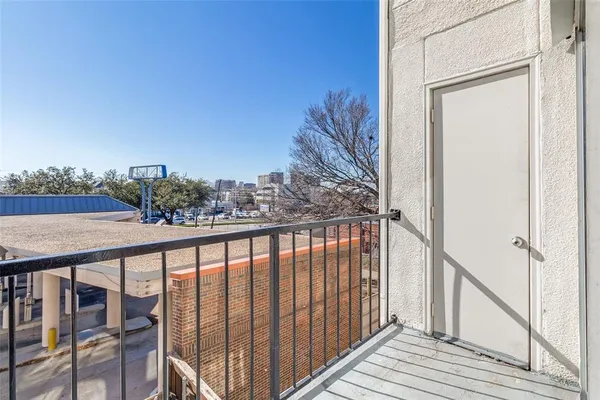 a view of a balcony with wooden floor and fence