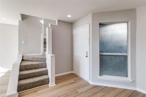 a view of a hallway with wooden floor and entryway