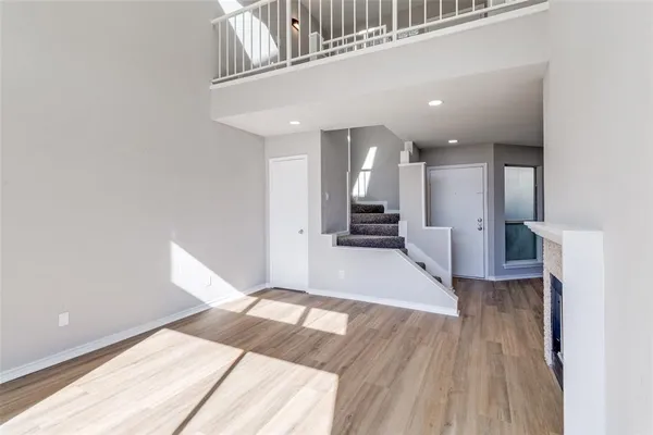 a view of a hallway with wooden floor and staircase