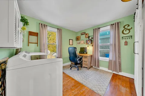 a view of a livingroom with workspace and a window