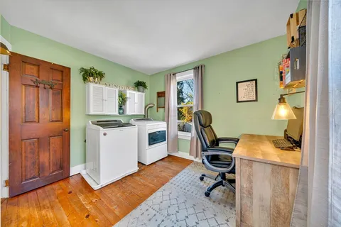 a view of a workspace with furniture and a window