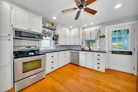 a kitchen with stainless steel appliances white cabinets and a stove