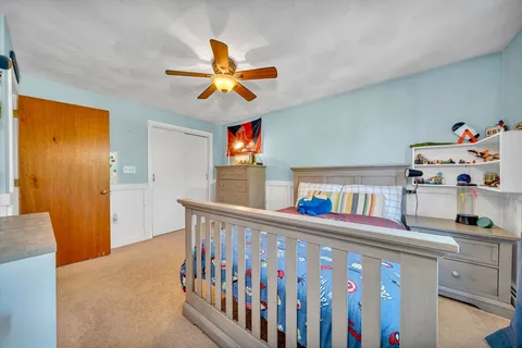 a bedroom with furniture a baby crib and a window