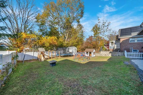 a view of a house with a yard patio and fire pit