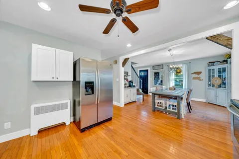 a living room with stainless steel appliances kitchen island granite countertop furniture and a wooden floor