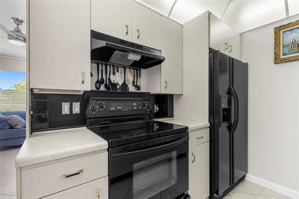 3028 Cambridge B, Unit 3028 Deerfield Beach, FL 33442 - Photo 12 of 49 a kitchen with a stove and a refrigerator