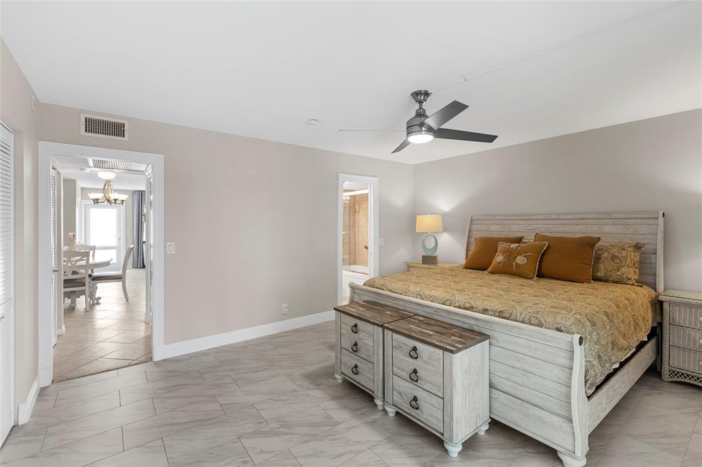 3028 Cambridge B, Unit 3028 Deerfield Beach, FL 33442 - Photo 14 of 49 a bedroom with a bed and a chandelier