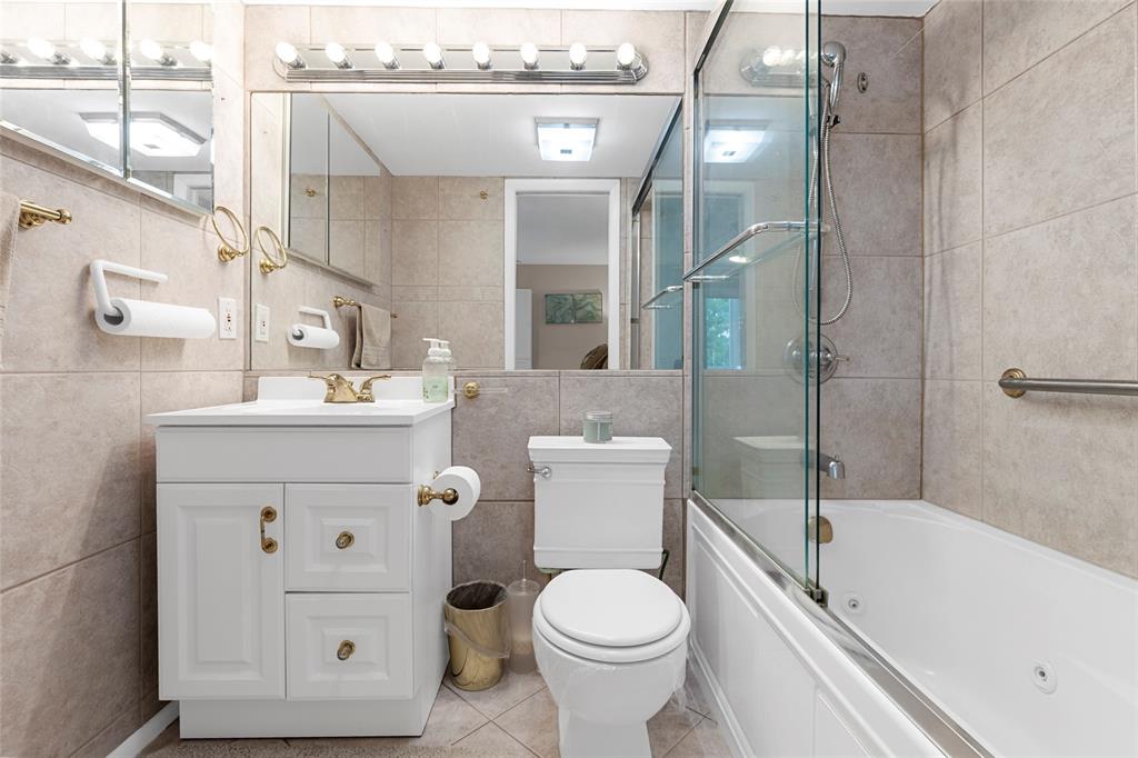 3028 Cambridge B, Unit 3028 Deerfield Beach, FL 33442 - Photo 20 of 49 a bathroom with a sink toilet vanity and bathtub