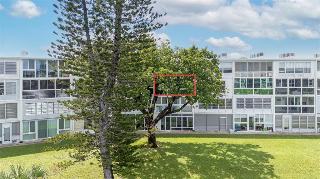 3028 Cambridge B, Unit 3028 Deerfield Beach, FL 33442 - Photo 27 of 49 a view of a large building with a large windows and plants