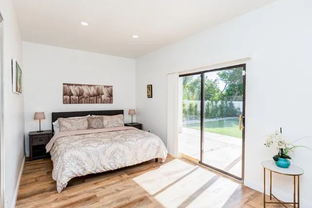 a bedroom with a large bed and a potted plant