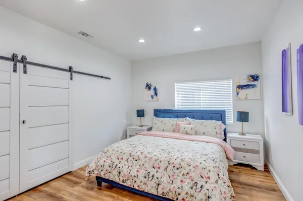 a bedroom with a bed and wooden floor
