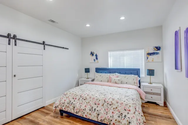 a bedroom with a bed and wooden floor