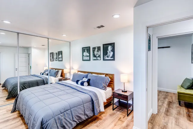 a bedroom with two beds and painting on the wall