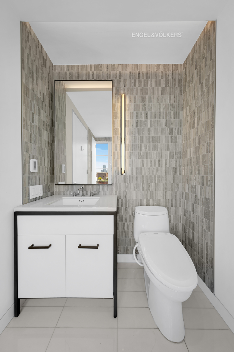 70 Charlton Street, Unit 21C Manhattan, NY 10014 - Photo 11 of 22 a bathroom with a toilet a sink and mirror