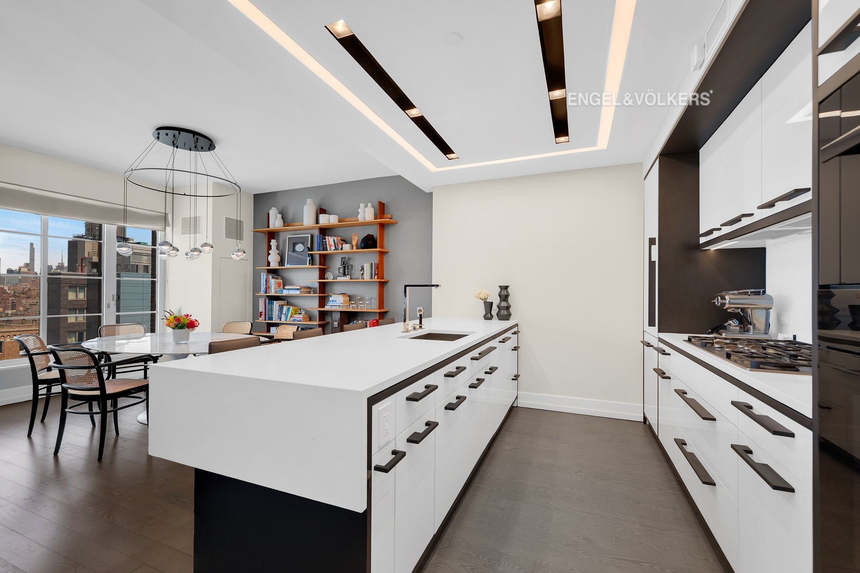 70 Charlton Street, Unit 21C Manhattan, NY 10014 - Photo 5 of 22 a kitchen with stainless steel appliances a white stove top oven a sink a dining table and chairs with wooden floor