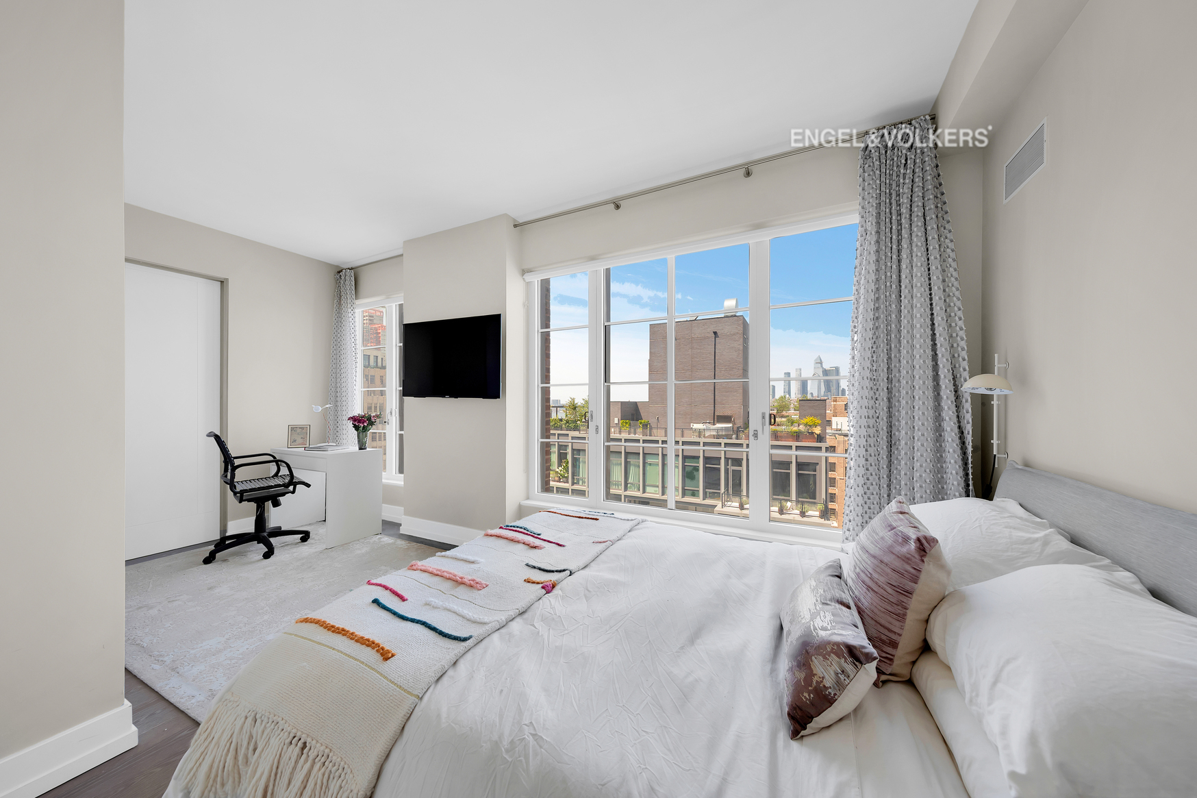 70 Charlton Street, Unit 21C Manhattan, NY 10014 - Photo 9 of 22 a bedroom with a bed and a flat screen tv