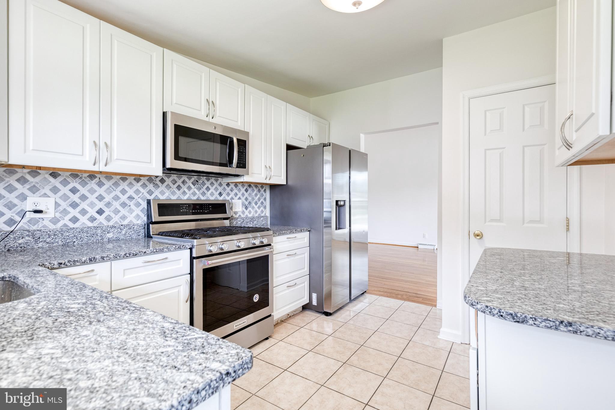 6653 Chippewa Drive Baltimore, MD 21209 - Photo 11 of 24 a kitchen with stainless steel appliances granite countertop a stove a sink and a microwave