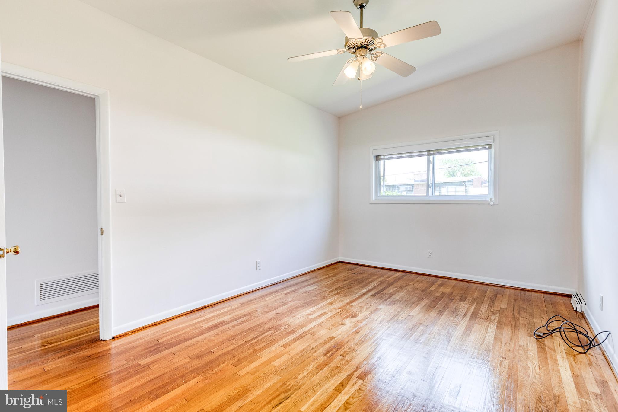 6653 Chippewa Drive Baltimore, MD 21209 - Photo 13 of 24 an empty room with wooden floor and windows