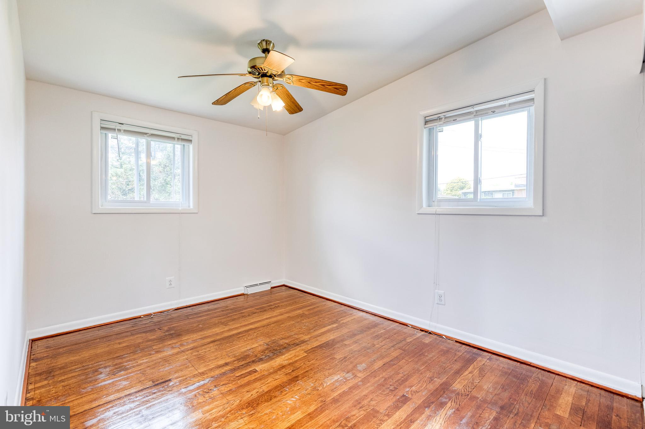 6653 Chippewa Drive Baltimore, MD 21209 - Photo 16 of 24 an empty room with wooden floor and windows