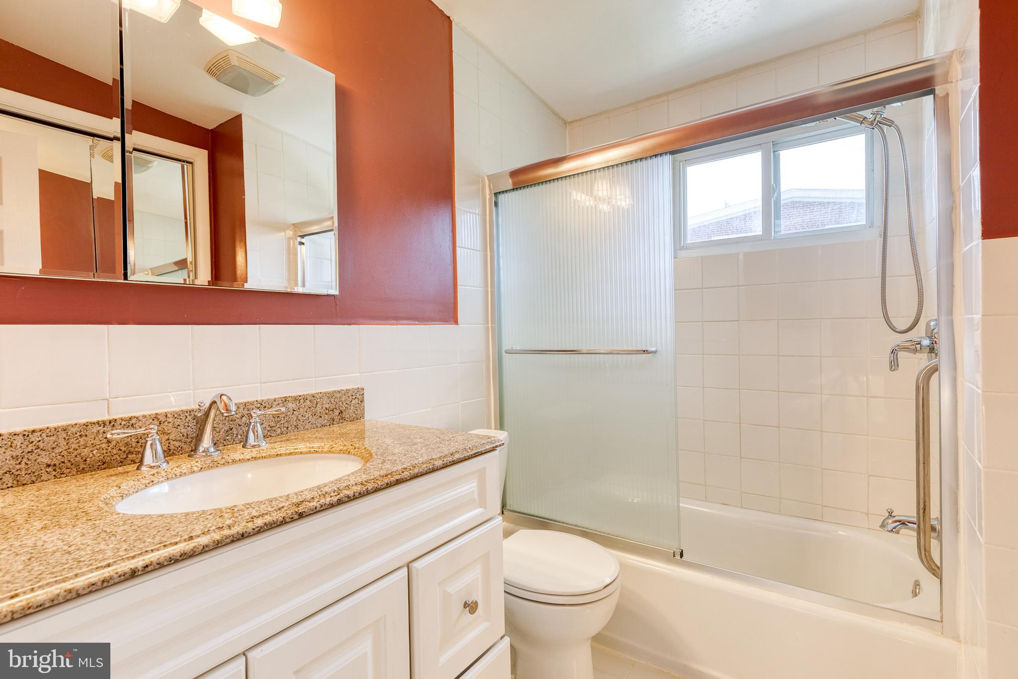 6653 Chippewa Drive Baltimore, MD 21209 - Photo 17 of 24 a bathroom with a granite countertop sink a toilet and shower