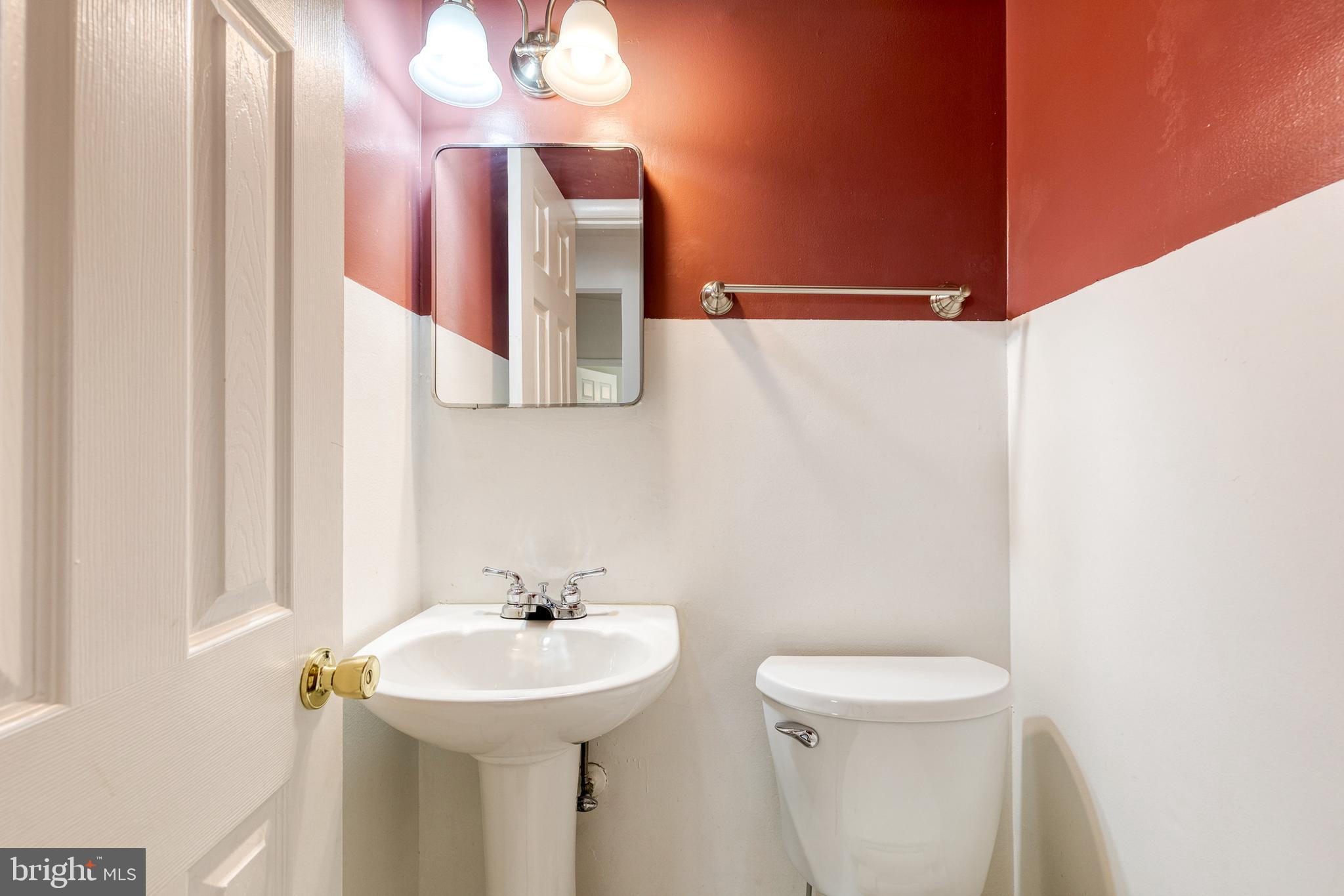 6653 Chippewa Drive Baltimore, MD 21209 - Photo 18 of 24 a bathroom with a sink a mirror and a toilet