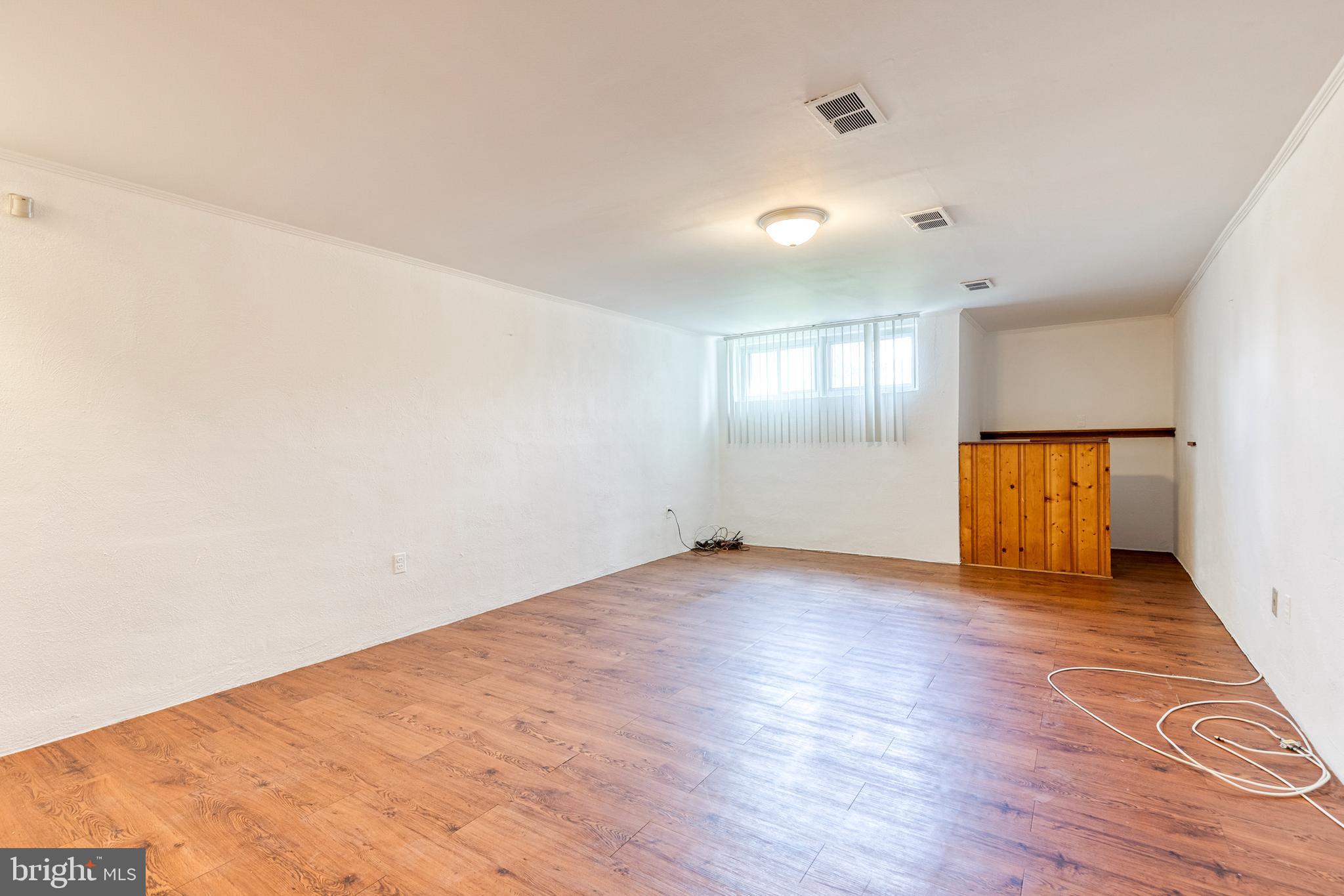 6653 Chippewa Drive Baltimore, MD 21209 - Photo 19 of 24 an empty room with wooden floor and windows