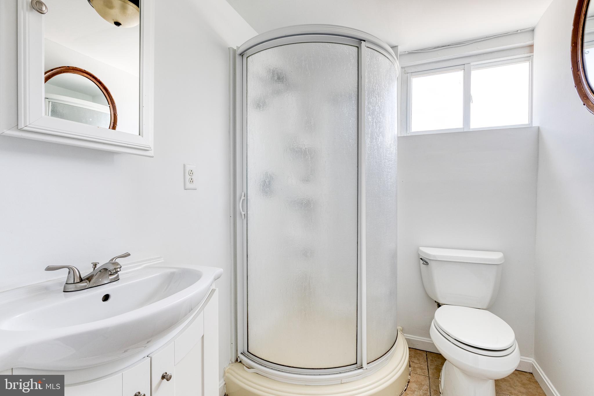 6653 Chippewa Drive Baltimore, MD 21209 - Photo 22 of 24 a bathroom with a sink a toilet and a mirror