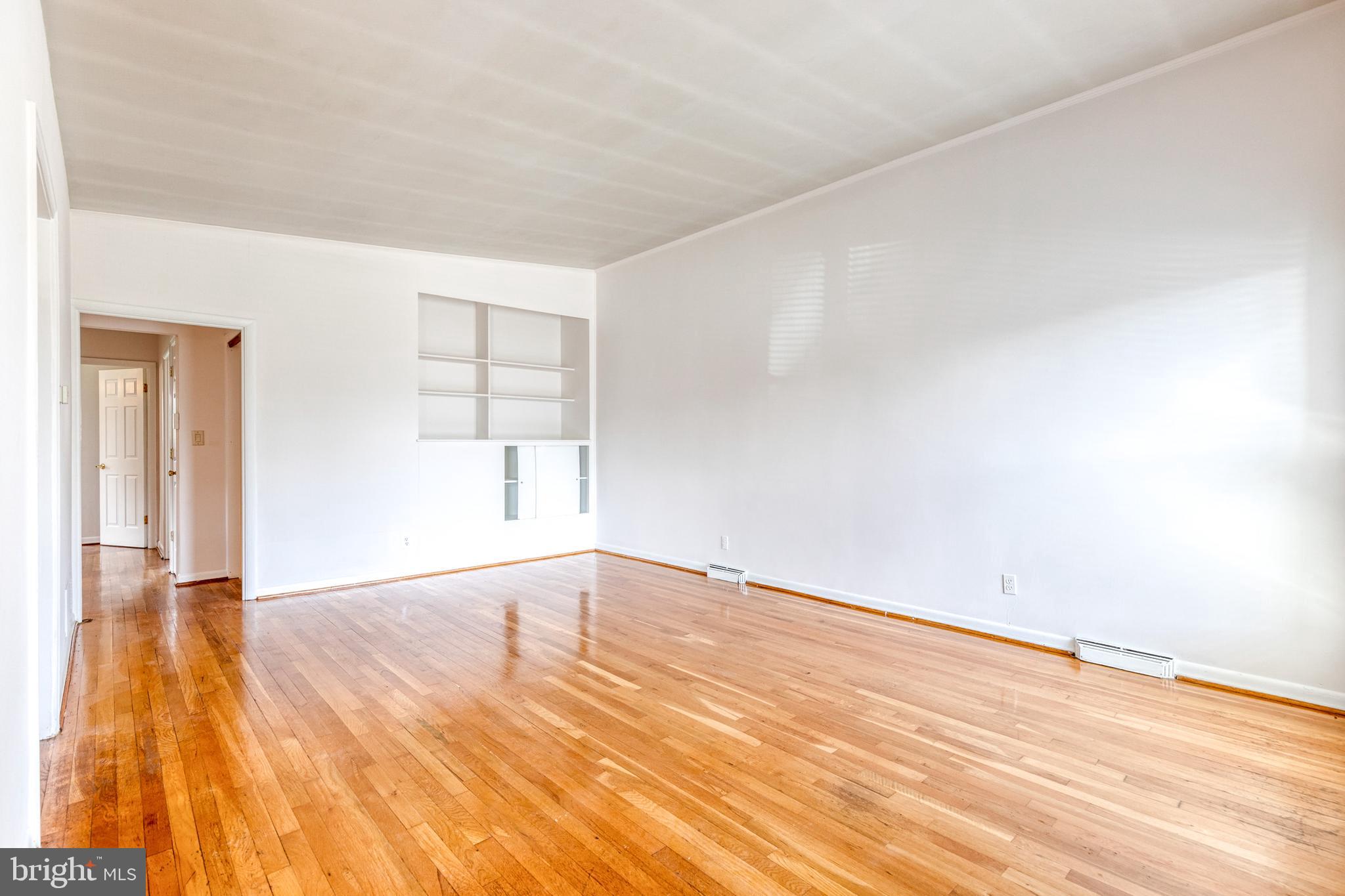 6653 Chippewa Drive Baltimore, MD 21209 - Photo 3 of 24 an empty room with wooden floor and windows