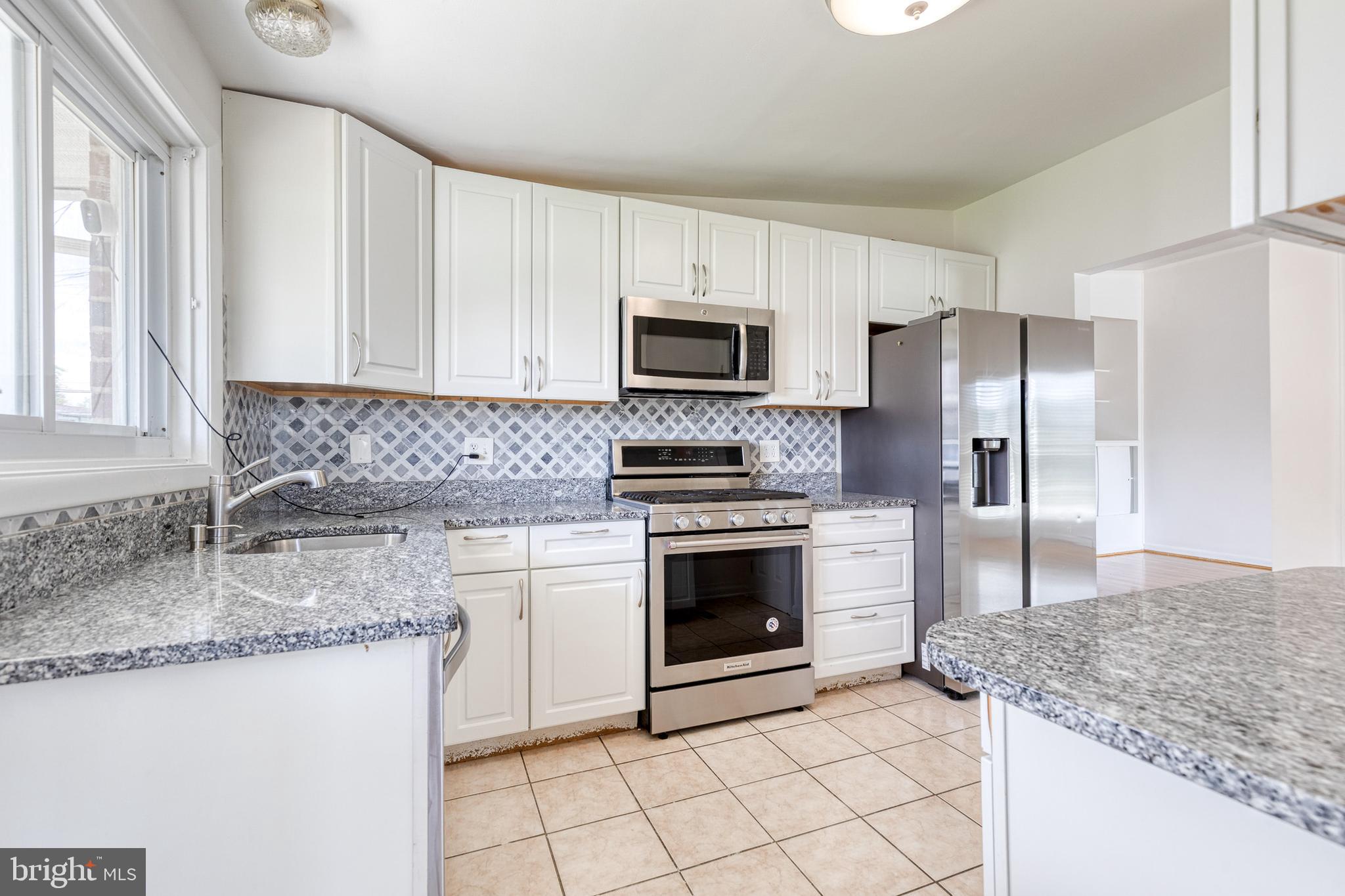 6653 Chippewa Drive Baltimore, MD 21209 - Photo 10 of 24 a kitchen with granite countertop a sink stove and refrigerator