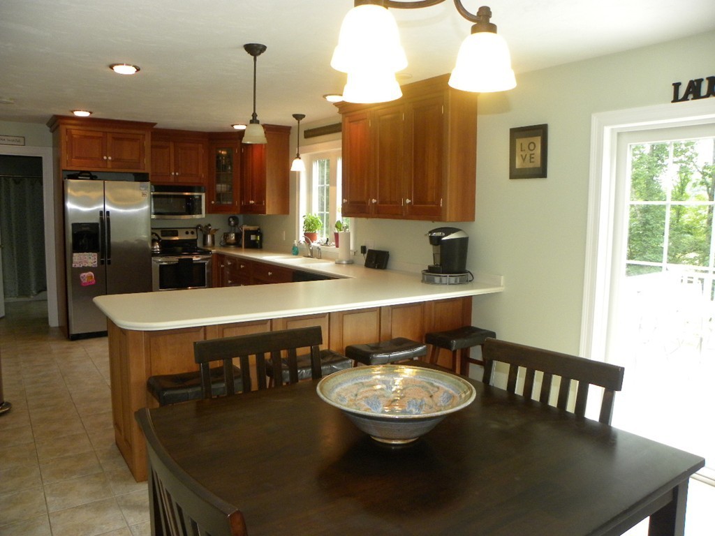 57 McIntyre Road Charlton, MA 01507 - Photo 22 of 30 a kitchen with a table chairs stove and refrigerator