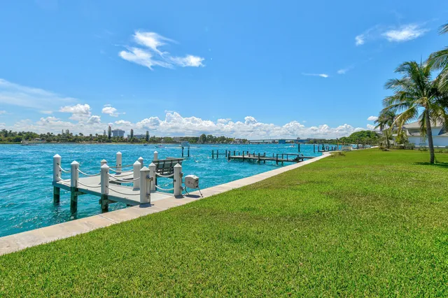 a view of a lake with lawn chairs and a table