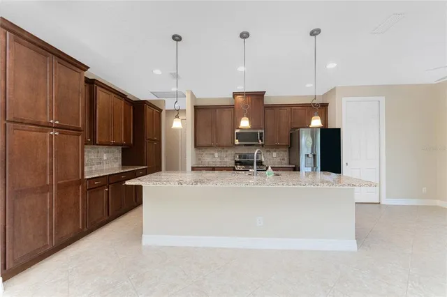 a view of an empty room and kitchen view