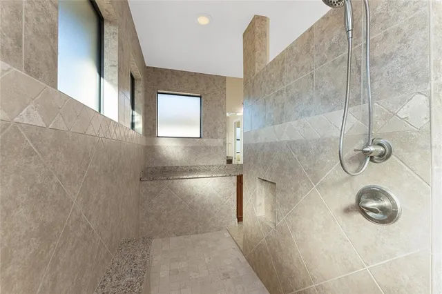 a bedroom with a bed chandelier and a window