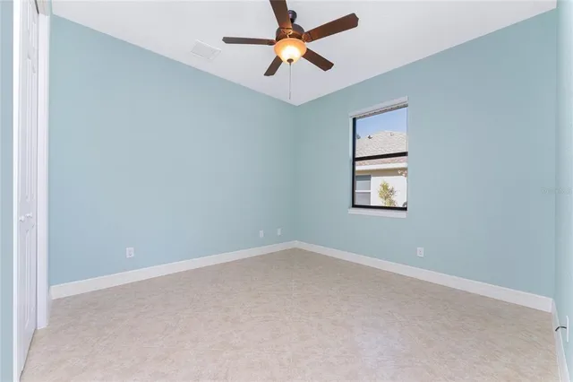 an empty room with a window and a fan
