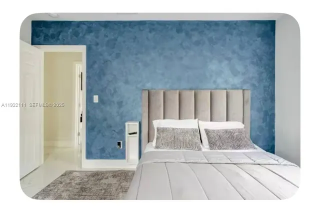 a bedroom with a bed a flat screen tv and a window