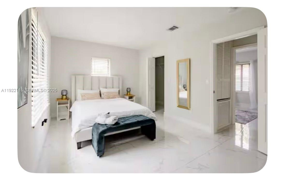 1301 Northwest 99th Street, Unit A Miami, FL 33147 - Photo 8 of 10 a spacious bedroom with a bed and a mirror