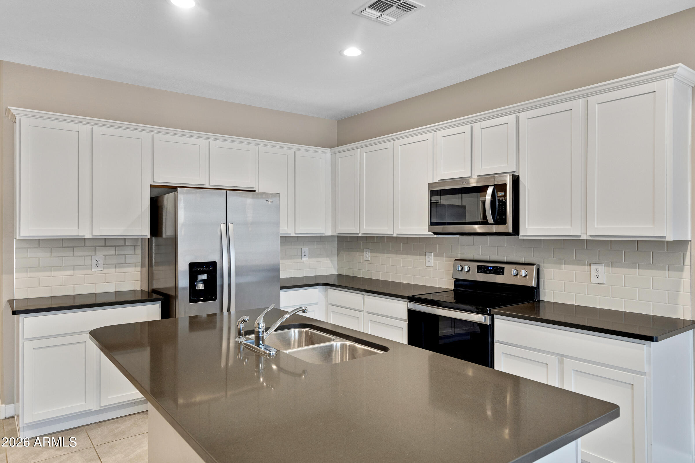 24220 West Ripple Road Buckeye, AZ 85326 - Photo 7 of 10 a kitchen with stainless steel appliances granite countertop a sink a stove and a refrigerator