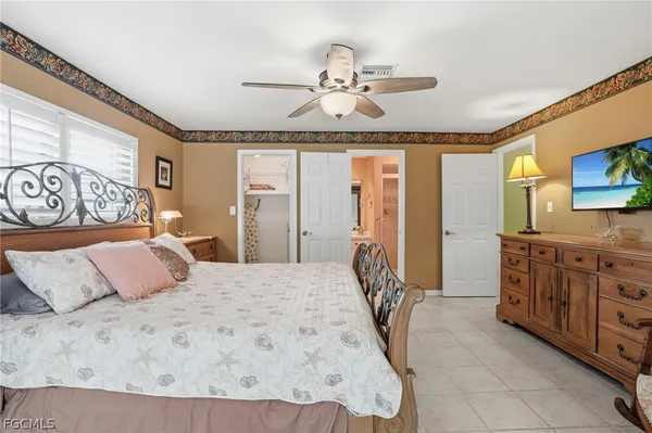 a bedroom with a large bed and a flat tv screen on dresser