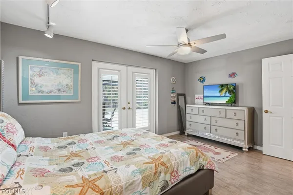 a bedroom with a bed dresser and wooden floor