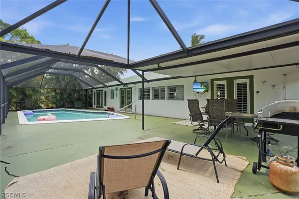 a view of a patio with table and chairs under an umbrella