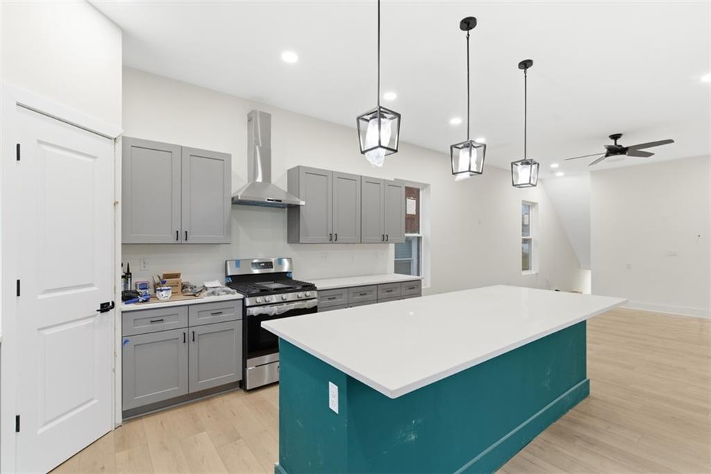 1361 Hawthorne Street Pittsburgh, PA 15201 - Photo 11 of 50 a kitchen that has a sink a stove and a wooden floor