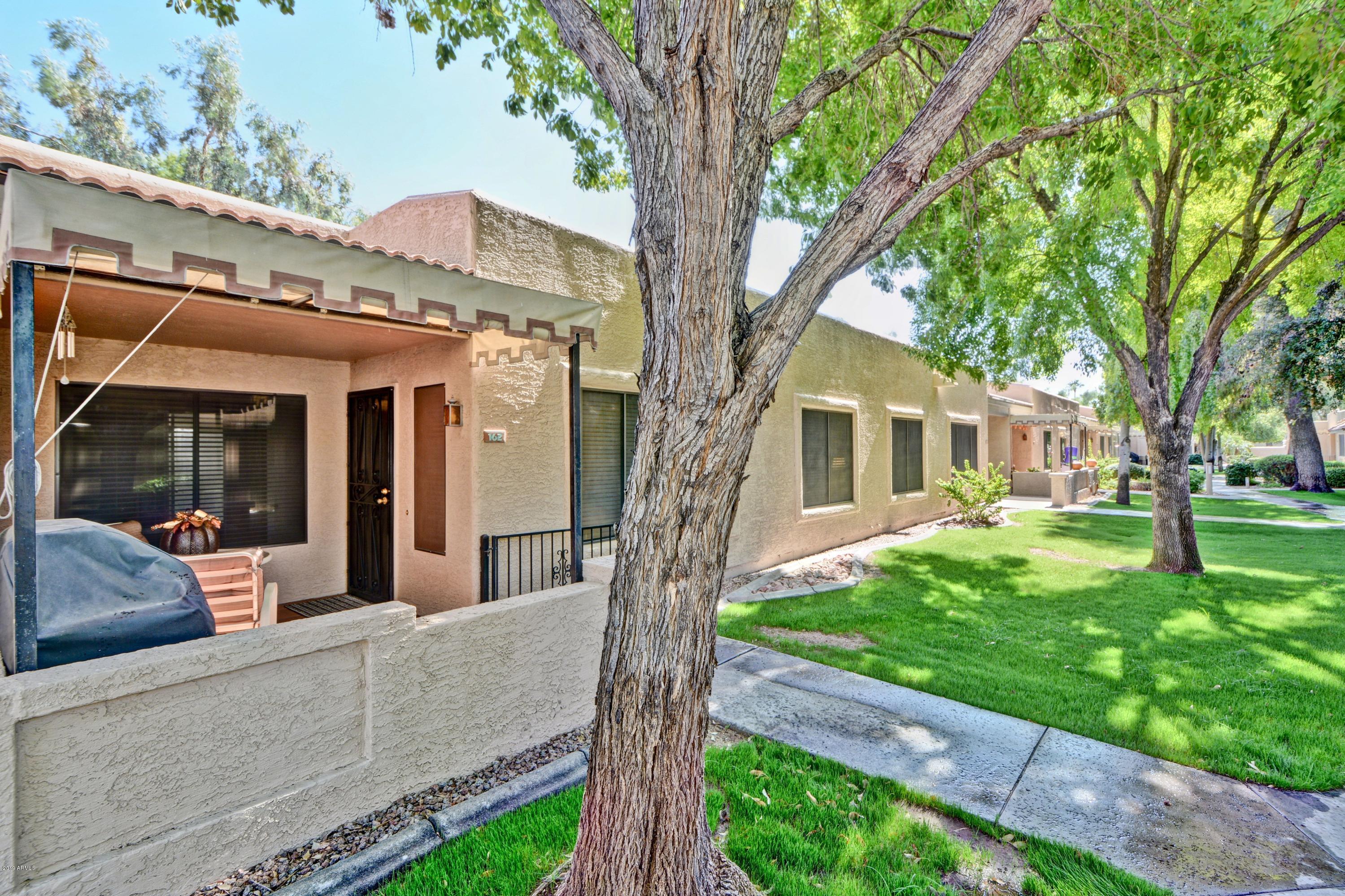 14300 West Bell Road, Unit 162 Surprise, AZ 85374 - Photo 12 of 23 a view of a house with backyard and a tree