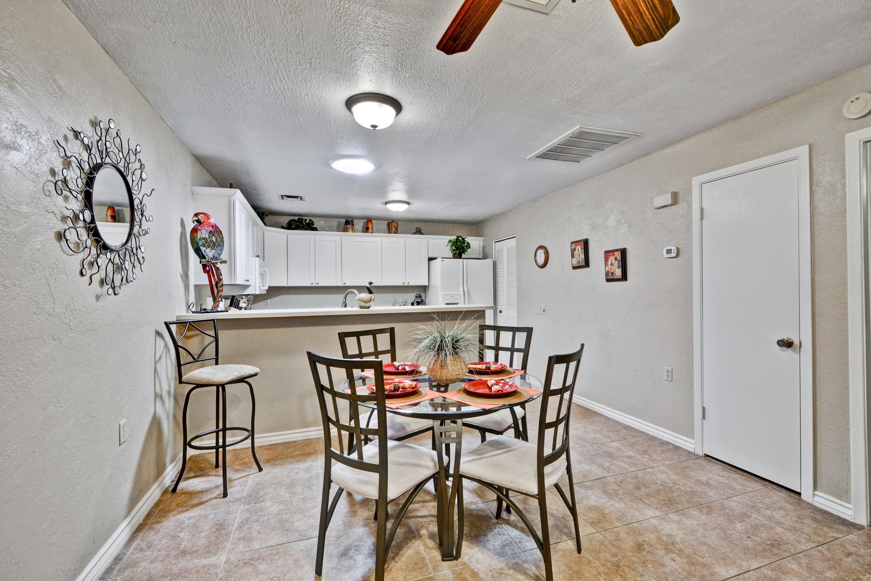 14300 West Bell Road, Unit 162 Surprise, AZ 85374 - Photo 4 of 23 a kitchen with a table and chairs in it